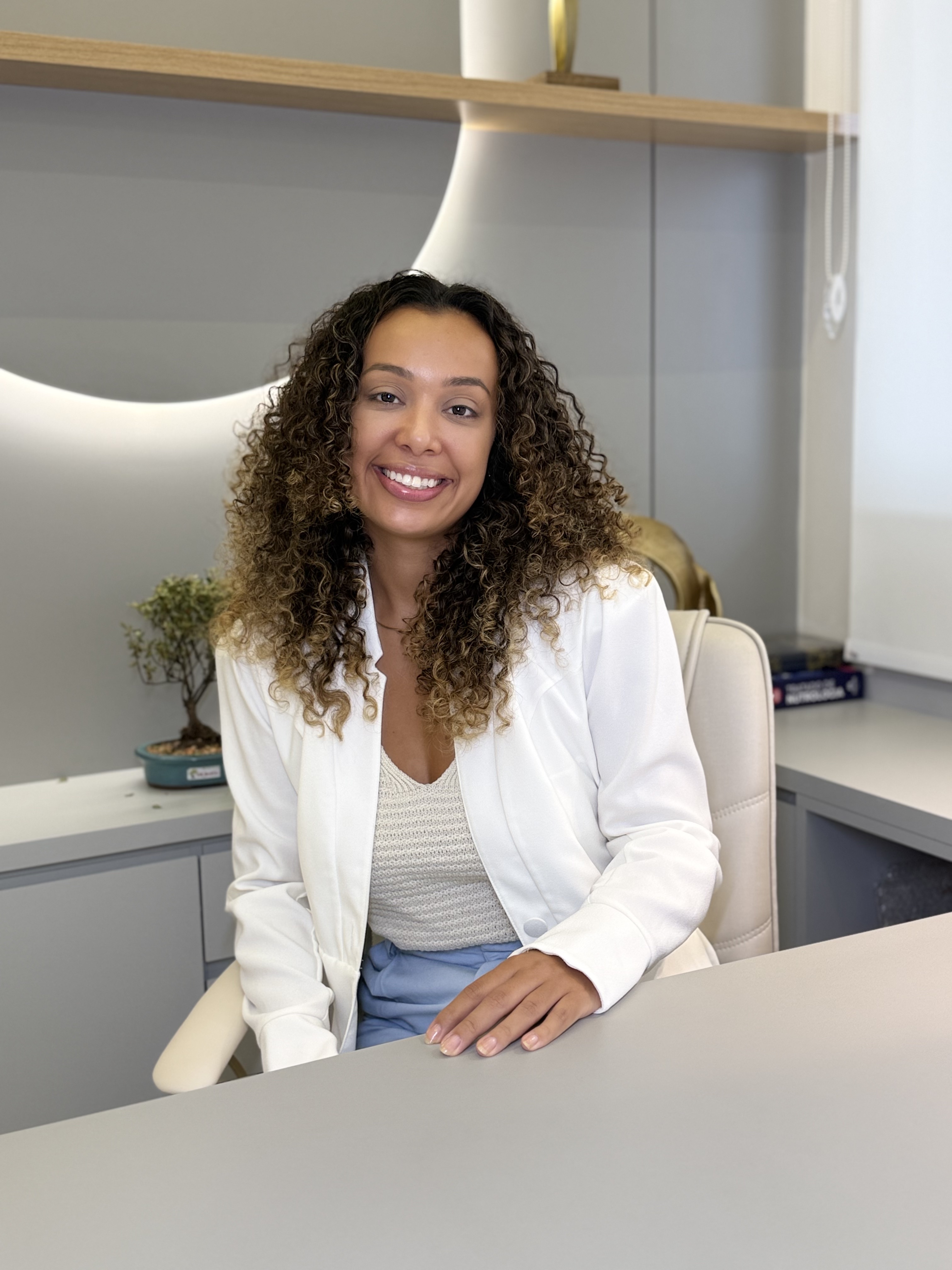 Dra. Amanda Clevelario sorrindo no consultório